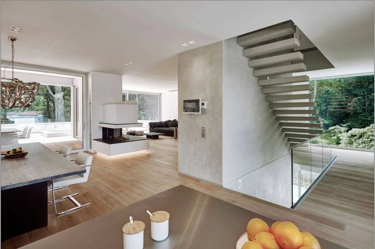 Offener Grundriss mit großen Fenstern, Treppe und Designkamin als Shootingkulisse