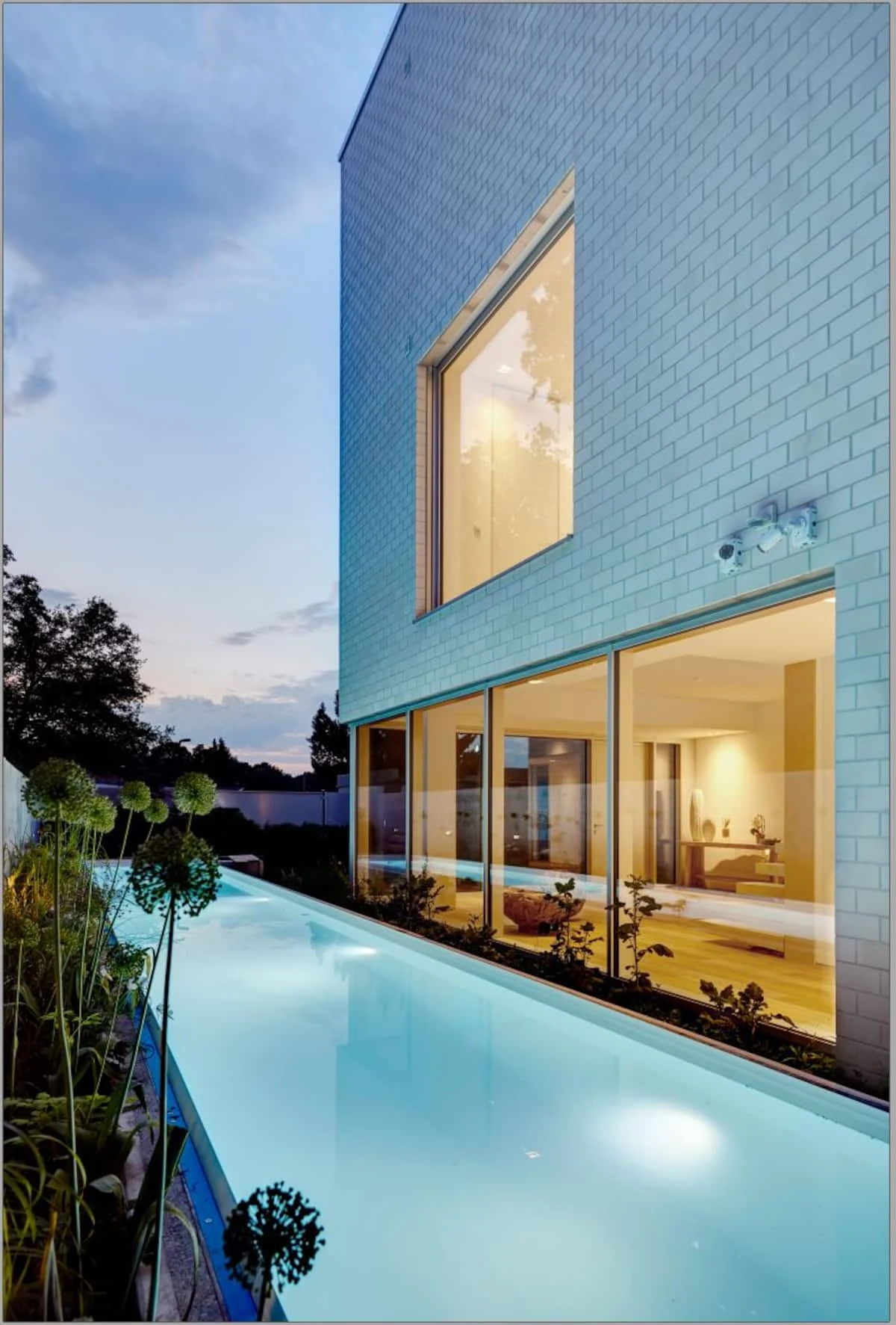 Beleuchtete Fassade des Lakehouse und Pool in der Abenddämmerung